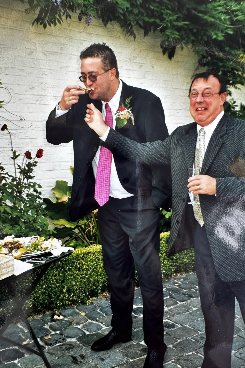 Archieffoto van papa Hedwin op een tuinfeest, met verse oesters en een glas bubbels